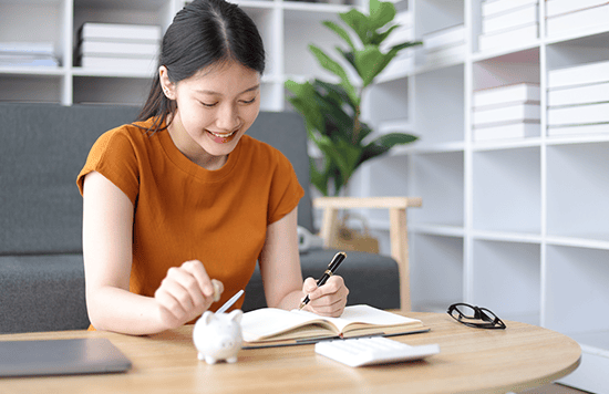 a girl happily writing in a notebook