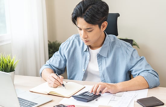 a boy computing budget with a calculator